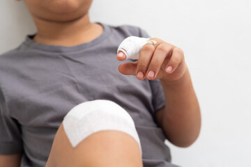 Close up of bandage on finger. Asian kid boy was accident injured while playing isolated on white background. Life insurance