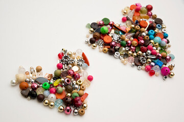 Frame in the shape of hearts. Background of multicolored decorative craft beads. Valentine's Day....