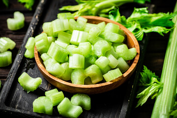Sliced fresh celery. On a dark wooden background.