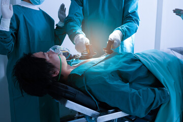 Doctors and nurses use defibrillators in the chest of an unconscious patient. To save lives while performing surgery in the operating room.