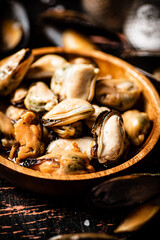 Pickled mussels in a wooden plate on the table. 