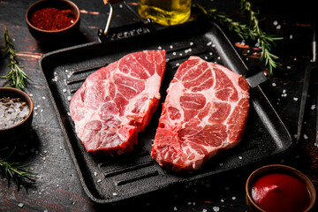 Raw steak pork in a grill pan with tomato sauce and spices. 