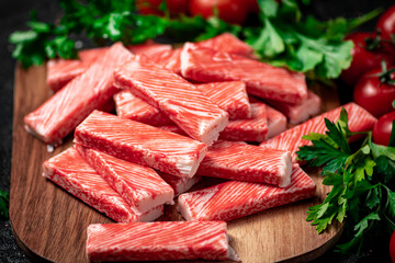 Fresh crab meat on a cutting board with parsley and tomatoes. 