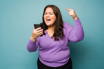 Upset woman looking stressed screaming during a phone call