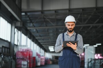 Factory technician working using digital tablet at factory warehouse.