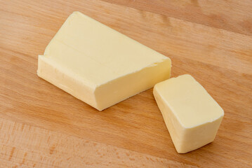 Block of butter cut on wooden cutting board