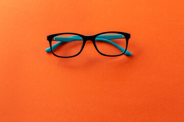 Stylish eyeglasses over orange background. Optical store, glasses selection, eye test, vision...