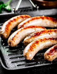 Grilled sausages in a frying pan. 
