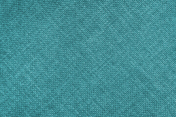 Jacquard woven upholstery, bright turquoise coarse fabric texture with diagonal weave lines. Textile background, furniture textile material, wallpaper, backdrop. Cloth structure close up.