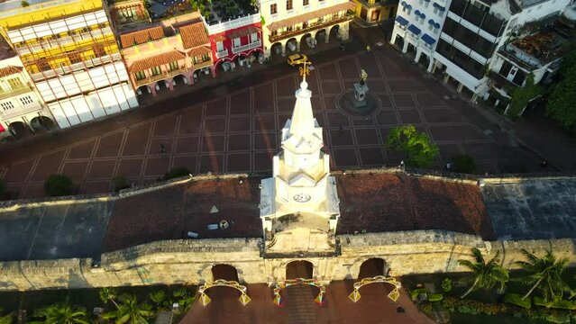 Aerial shot drone pans up in front of clock tower to reveal Plaza de los Coches and the historic center