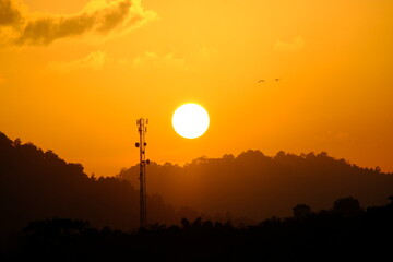 Gorgeous panorama scenic of the strong sunrise with silver lining and cloud on the orange sky