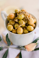 Various olives flavored with spices in white cup and glass jar. Green olives, black olives. Front and top shot on a white background
