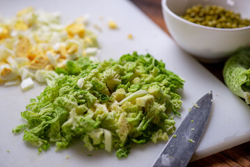 Preparation of a vegetarian savoy cabbage salad. Chopped savoy cabbage on a cutting board.