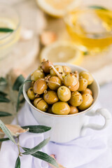 Various olives flavored with spices in white cup and glass jar. Green olives, black olives. Front and top shot on a white background