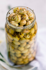 Various olives flavored with spices in white cup and glass jar. Green olives, black olives. Front and top shot on a white background