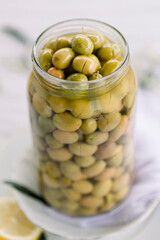 Various olives flavored with spices in white cup and glass jar. Green olives, black olives. Front and top shot on a white background