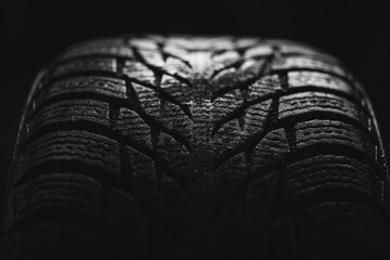 cool photo of a tire tread of a car wheel on a black background © Tsyb Oleh