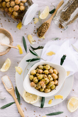 Various olives flavored with spices in white cup and glass jar. Green olives, black olives. Front and top shot on a white background