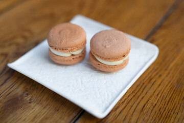 various delicious macaron cookies on a square plate stand.