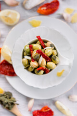 Various olives flavored with spices in white cup and glass jar. Green olives, black olives. Front and top shot on a white background