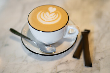 a fragrant and warm mug of cappuccino with a drawing heart, on table.
