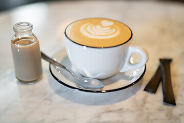 a fragrant and warm mug of cappuccino with a drawing heart, on table.