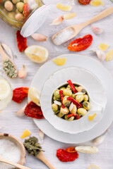 Various olives flavored with spices in white cup and glass jar. Green olives, black olives. Front and top shot on a white background