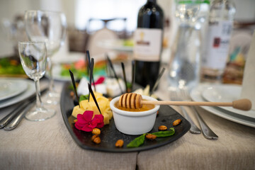 a dish of various delicious cheeses and a plate of honey.
