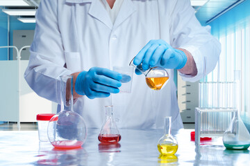 Doctors hands with test tube. Scientist pours liquid in volumetric flask. Laboratory assistant...