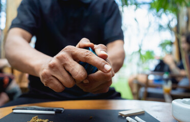 Young man making cigarettes with medical marijuana