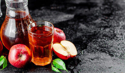 Apple juice in a jug and a glass on the table. 