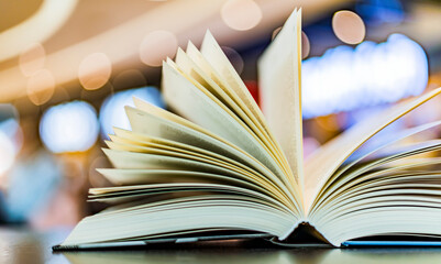 An open hardcover book on a table in a public library