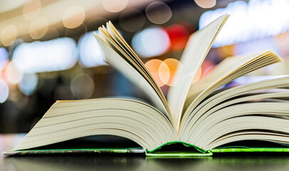An open hardcover book on a table in a public library