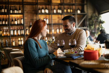 Valentines day couple sitting in favourite caffe, exchanging gifts in hart shape, couple cudling and hugging