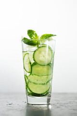 Fresh cucumber water with green leaves basil