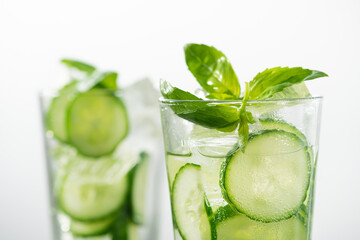Fresh cucumber water with green leaves basil