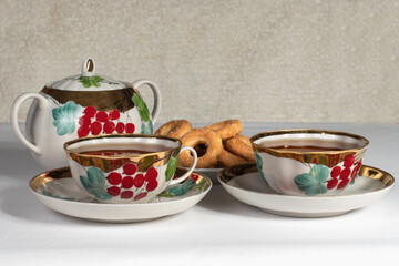tea set with cookies on a white tablecloth