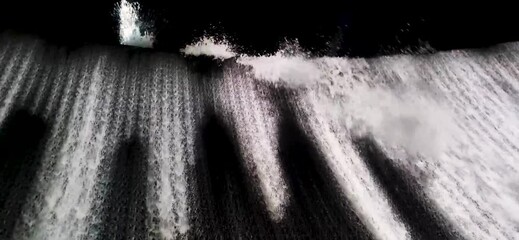 Water splashes pouring down from artificial waterfall. Outdoors