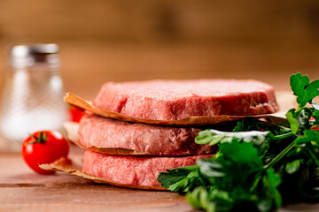 Raw burger with fresh tomatoes. 