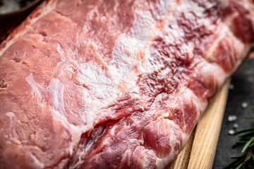 A fresh piece of raw pork on a cutting board.