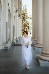 portrait of a young bride girl in a light dress in an urban environment