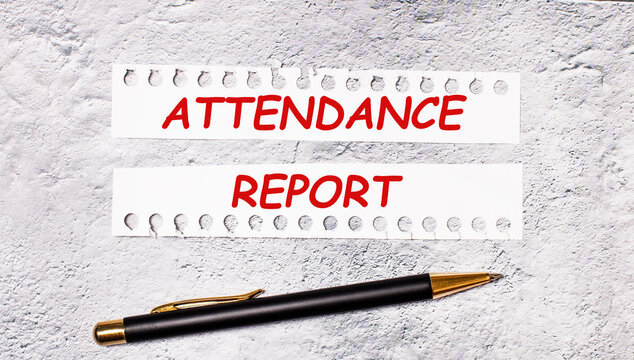 On a marble background are two torn strips of white paper with the text ATTENDANCE REPORT and a black pen.