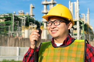 engineer manager wear safety helmet uniform talk with engineer team with radio walkie talkie during work with refinery, petrochemical, petroleum in chemical plant business background