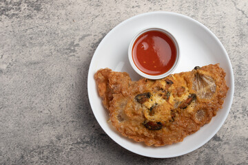 Fried mussels in crispy batter in a white plate