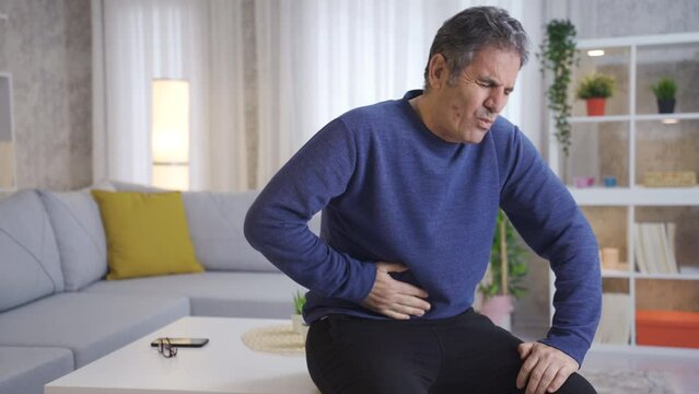 Mature man has stomach ache.
Frustrated mature man suffering from stomach ache at home. Stomach cancer, pancreas.
