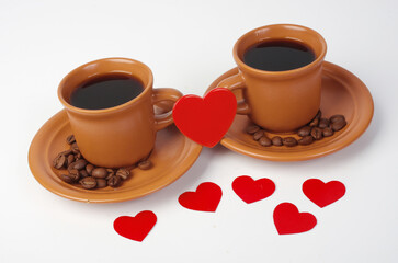 Two cups of coffee and a red heart between them.