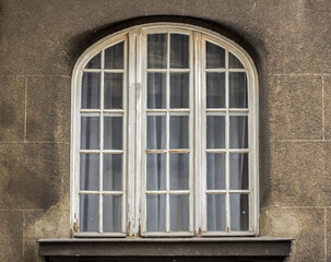 Fototapeta na wymiar Vintage weathered wooden window with arch on old house