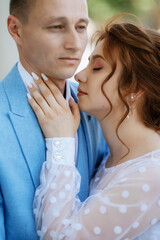 bride in a light wedding dress to the groom in a blue suit