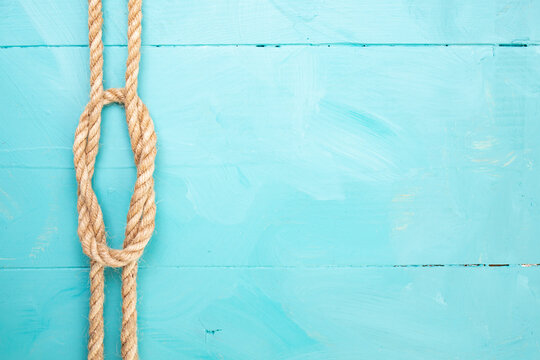 Jute rope with a knot on blue painted boards, marine backdrop