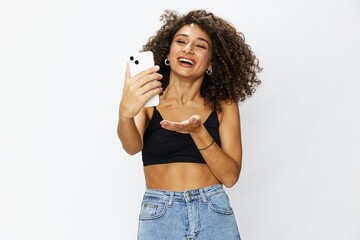 Woman blogger with phone in hand on white background selfies, video call, freelancer influencer job in social media and media, technology for work, smile curly hair copy spot